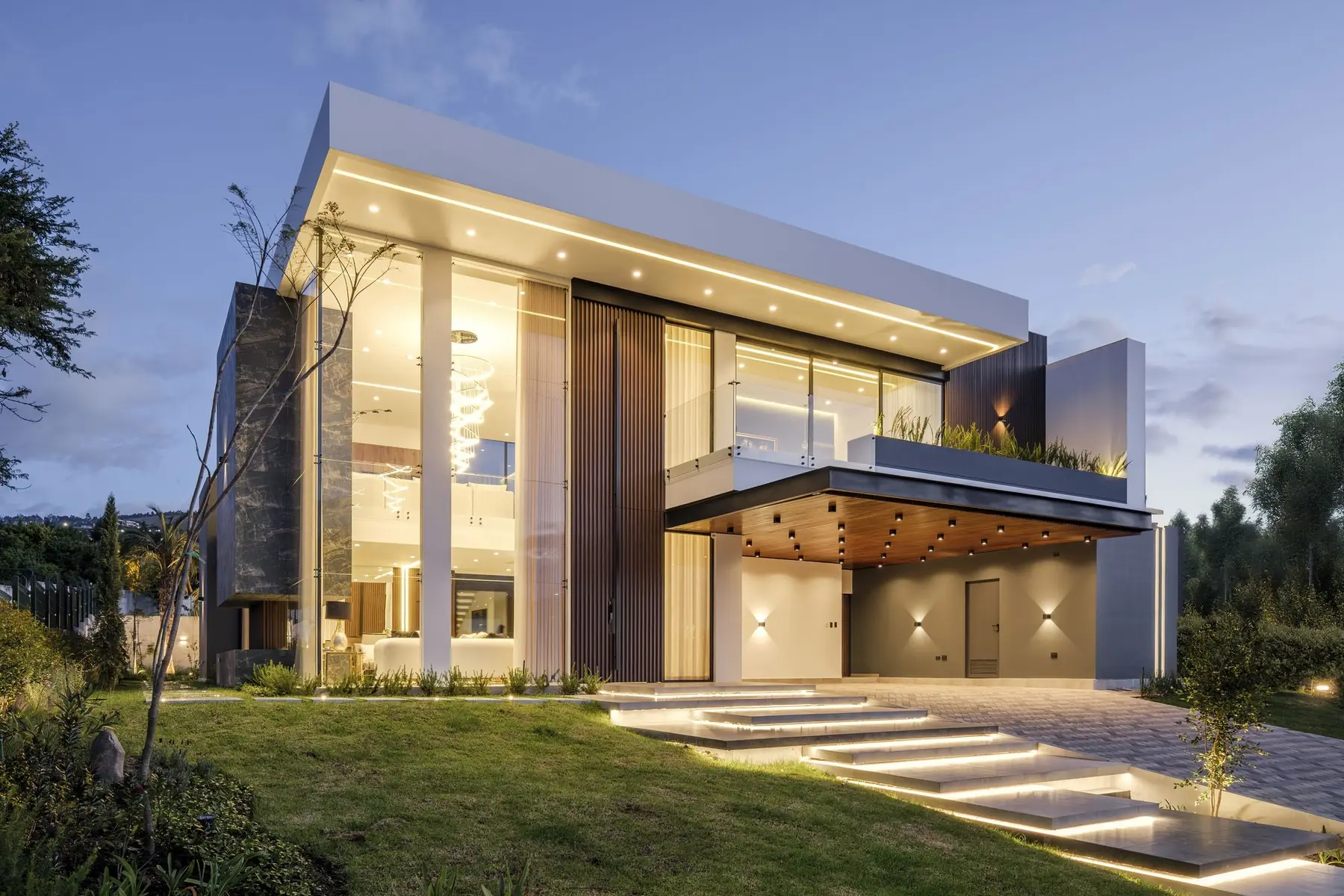 Casa moderna construida por PIVOT Constructores, constructora en Quito, iluminada al atardecer